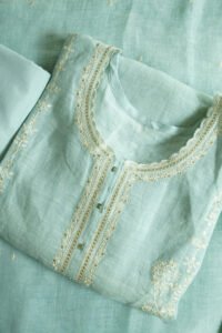 Traditional kurti named "Kanya," featuring intricate embroidery along the neckline, placket, and sleeves. Lightweight and graceful, it blends timeless craftsmanship with a minimalist silhouette—ideal for warm-weather elegance.