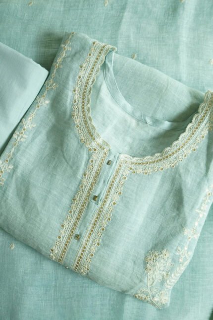 Traditional kurti named "Kanya," featuring intricate embroidery along the neckline, placket, and sleeves. Lightweight and graceful, it blends timeless craftsmanship with a minimalist silhouette—ideal for warm-weather elegance.