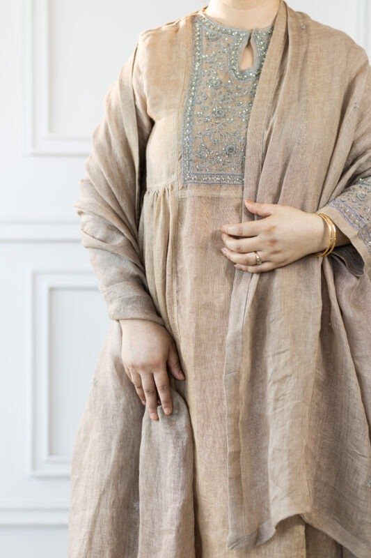 Side profile showing sleeve cuff embroidery and gold bangles