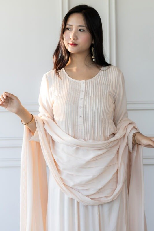 Woman wearing blush pink Pavitra Anarkali kurti with pleated bodice