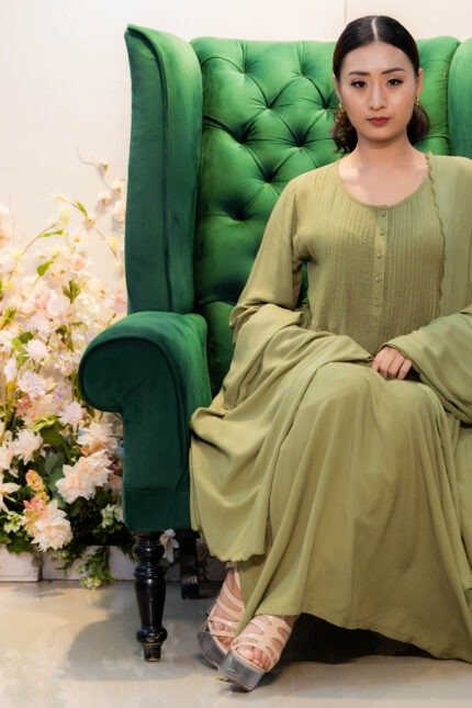 Model seated on a tufted armchair wearing Verdant Veil kurti with matching dupatta