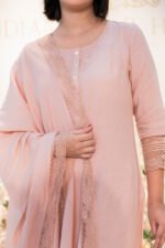 Close-up of hand holding lace-trimmed dupatta from Blush Raag set