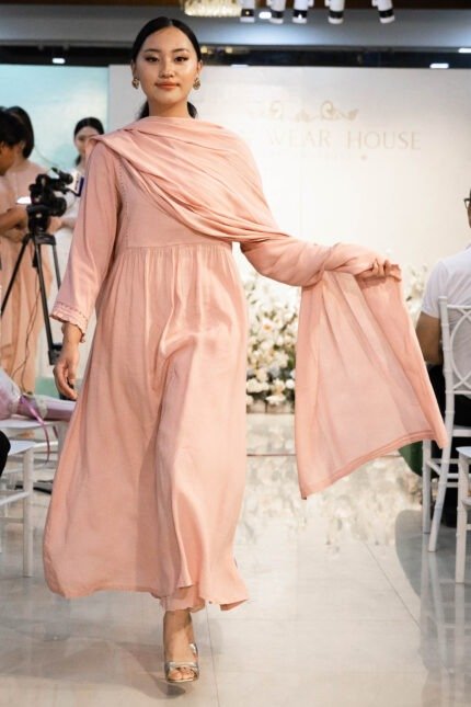 Model walking down runway in Aangan Aura ensemble during fashion show