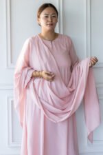 Editorial shot of Sharvani kurti in natural light against white paneled wall