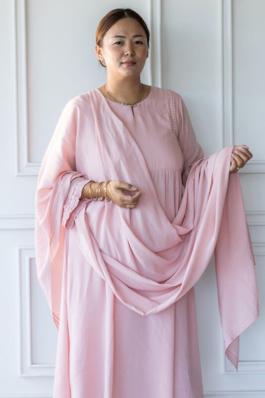 Editorial shot of Sharvani kurti in natural light against white paneled wall