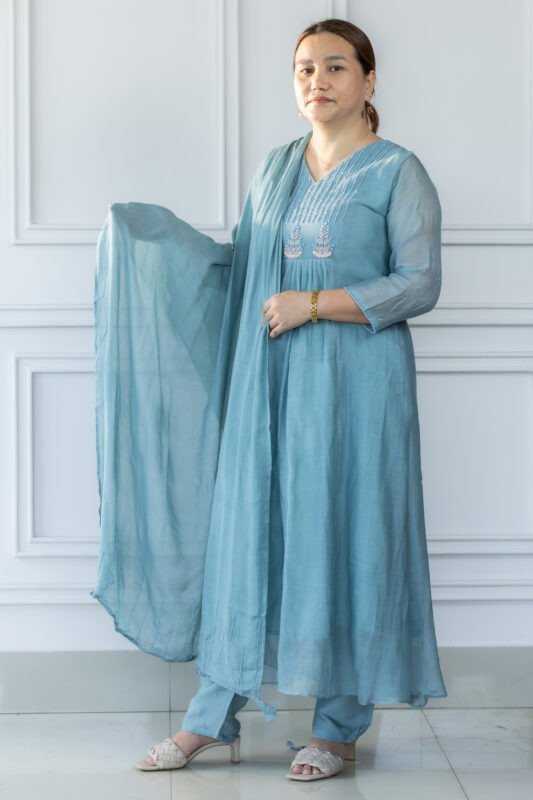 Woman wearing light blue kurti with floral embroidery and sheer sleeves