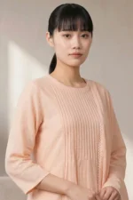 Studio portrait of a woman wearing the light pink Ora Ethnic kurta-pant set, with a long matching chiffon dupatta.