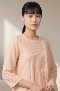 Studio portrait of a woman wearing the light pink Ora Ethnic kurta-pant set, with a long matching chiffon dupatta.