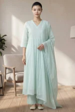 Full-length studio photo of a model in the Nysa Weaves V Neck seafoam green set, featuring a gathered-waist kurta, straight trousers, and a matching lace-bordered dupatta.