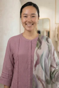 Woman wearing the Rang mauve linen kurti paired with a vibrant watercolor-style floral dupatta.