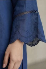 Close-up of intricate white floral embroidery on the sleeve of a cornflower blue Vogue linen kurti.