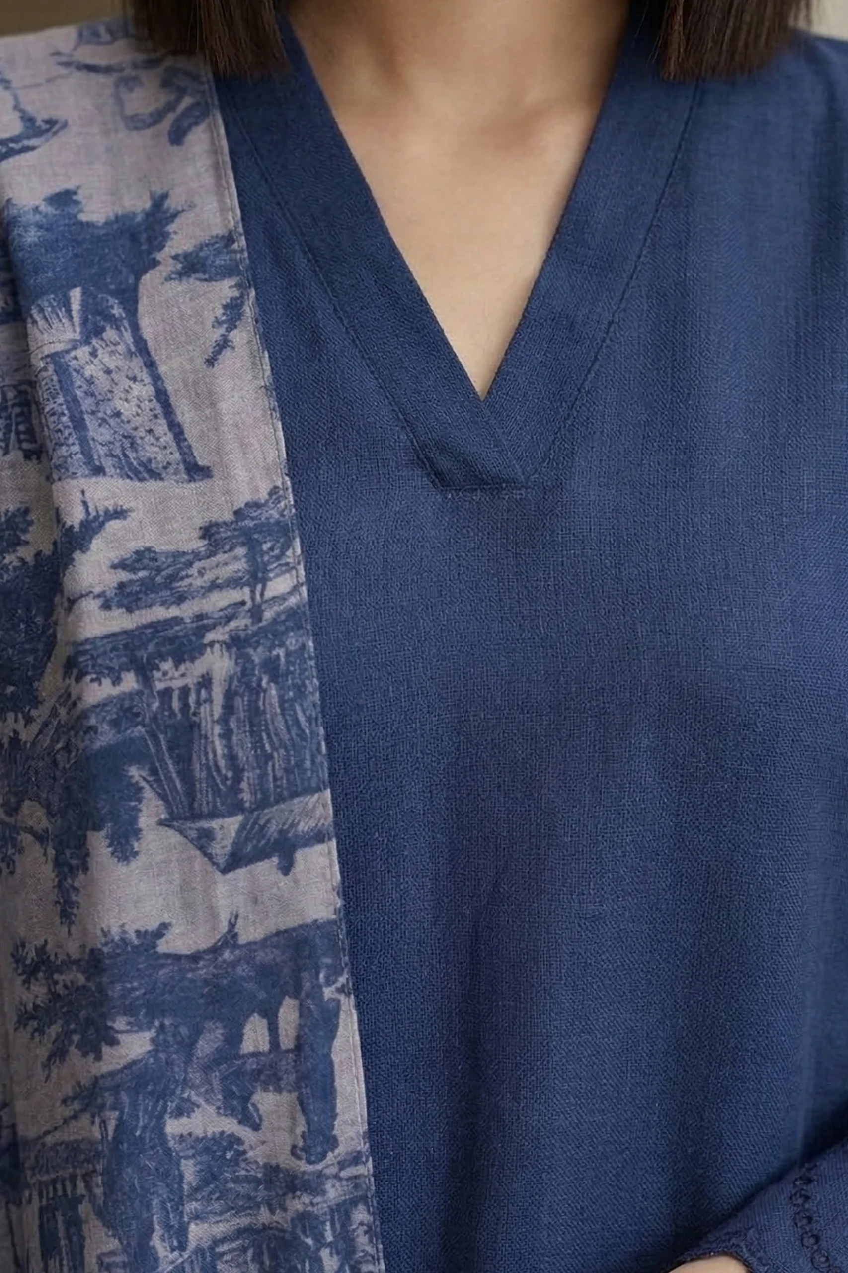 Woman wearing a blue Vogue linen kurti featuring a V-neckline paired with a multi-colored floral print dupatta.