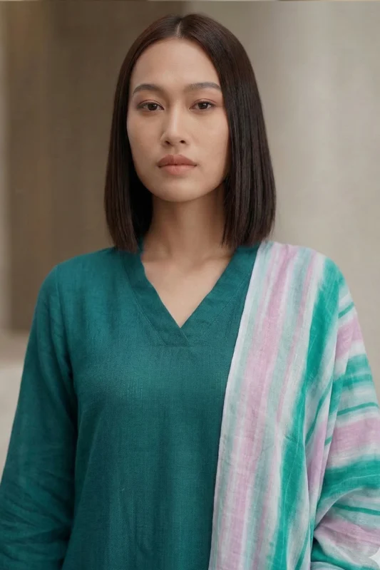 Woman wearing a teal Vogue linen kurti featuring a V-neckline and a multi-colored striped dupatta.