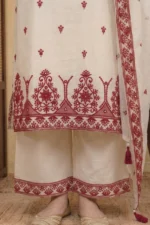 A detailed shot of the lower portion of the StyleMélange ensemble. The natural beige kurta features an intricate, oversized maroon scalloped embroidery pattern at the hem, detailed with geometric motifs and tiny mirrors. The wide-leg palazzos show a coordinating maroon embroidered border at the ankles, finished with traditional gold-toned juttis.