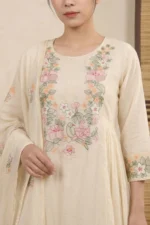 A detailed close-up of the kurti's bodice, showcasing an intricate U-shaped floral embroidery pattern featuring various blossoms and leaves. The design is accented by soft gathers and pleats below the bust, emphasizing the garment's feminine silhouette.