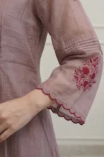 A focused close-up of the three-quarter length sleeve, highlighting a broad embroidered cuff with delicate floral patterns and contrasting thread work. The fabric shows a rich, premium texture.