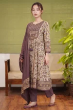 A full-length shot of a model wearing the Amara mauve and cream floral print Anarkali suit set, featuring a flared kurta, solid trousers, and a matching dupatta with a printed border.