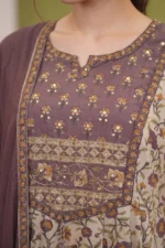 Close-up of the Amara kurti's bodice showing the mauve fabric with delicate gold sequin floral embroidery and a contrasting printed border along the waistline.
