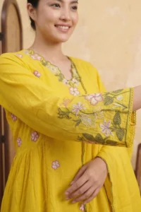 Close-up of the Golden Petal Kurta Set in yellow cotton with intricate pink and green floral embroidery on the bell sleeve and neckline