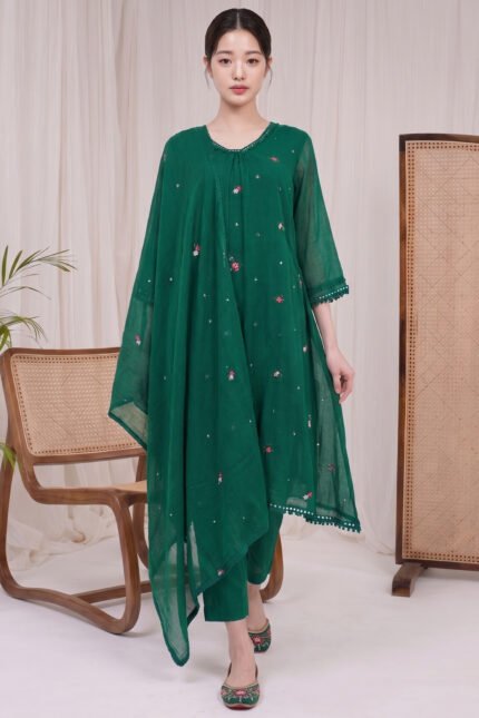 Full body view of a model wearing the Jade Kurti Set, a deep green ethnic suit featuring scattered floral embroidery, matching trousers, and a coordinating dupatta with decorative borders.