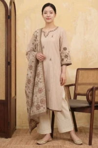 A woman wearing the Mocha Bloom Kurta Set comprising a straight-cut pink striped kurta with brown floral embroidery and fringe sleeve hem, off-white wide-leg pants, and a striped dupatta with large brown and green floral embroidered border, styled with gold juttis