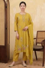 A woman wearing the Mustard Vine Kurta Set comprising a straight-cut floral embroidered kurta with vine motifs, matching straight-leg pants, and a flowing dupatta, styled with gold juttis