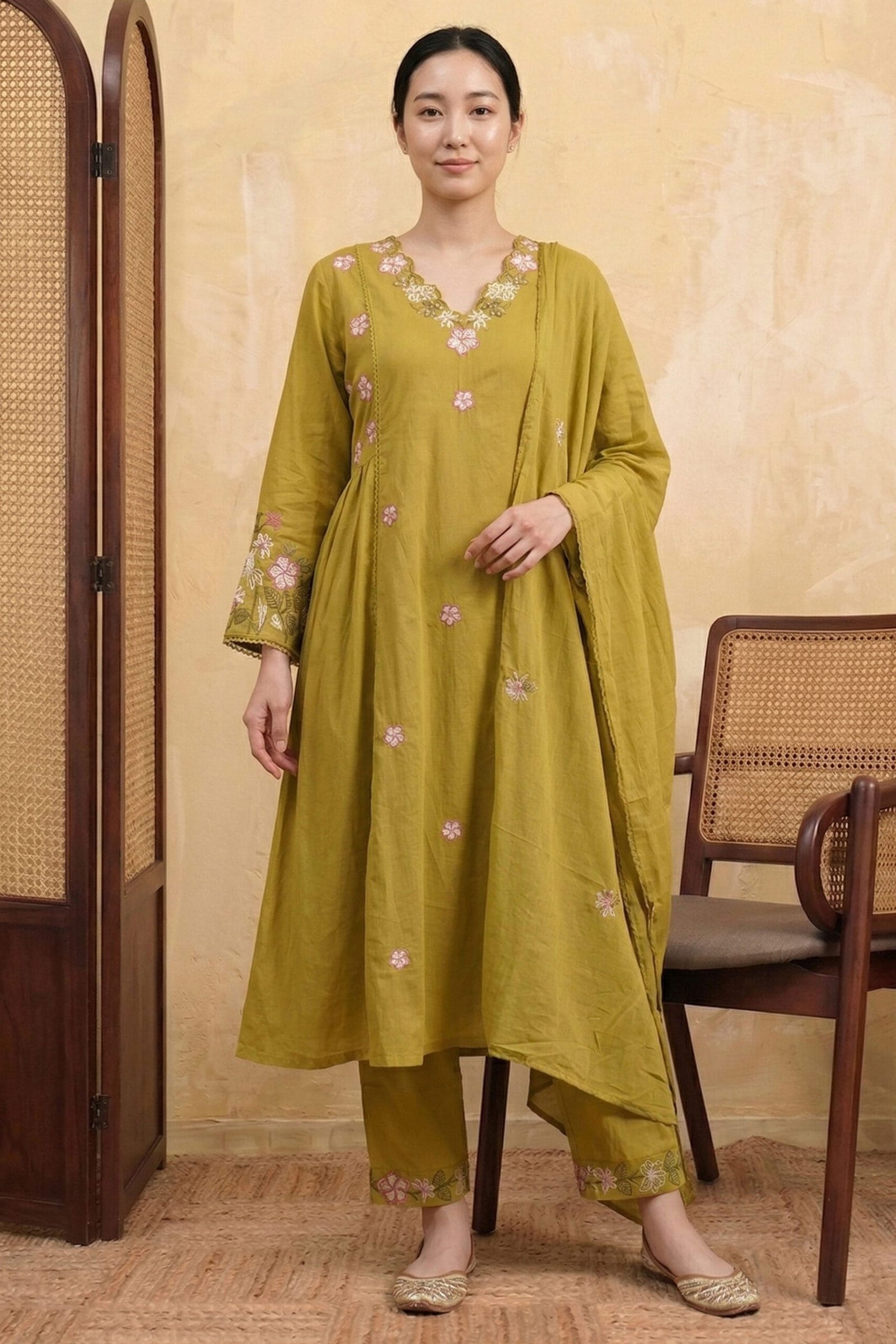 Sage-Bloom-Kurta-Set-–-Full-Look-with-Dupatta-and-Pants A woman wearing the Sage Bloom Kurta Set comprising a floral embroidered A-line kurta in olive green with scattered pink floral motifs, matching straight-leg pants with embroidered hem, and a plain dupatta, styled with gold juttis