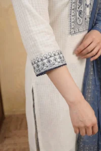 Close-up of the White Indigo Kurta Set showing a three-quarter sleeve with navy blue vine and leaf threadwork embroidery band and a delicate navy crochet lace trim at the cuff on white textured check cotton fabric