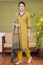 Full-length view of a mustard yellow Amber Ethnic Set featuring a paisley print kurta, solid tailored trousers, and a geometric grid pattern dupatta.