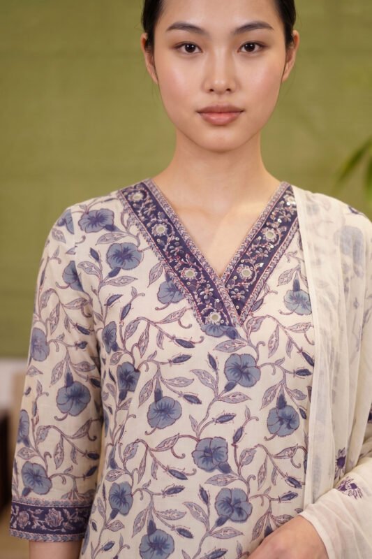 Close-up of the Cerulean Print Kurti highlighting the structured V-neckline, adorned with a contrasting dark blue patterned border and subtle mirror work against the natural kora background.