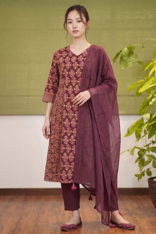 Full-length view of a women's deep wine ethnic set featuring a block-printed kurta, matching trousers, and a sheer dupatta.
