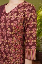 Detailed view of the three-quarter sleeves and side panel of a deep wine ethnic suit showcasing traditional Indian paisley and striped border prints.