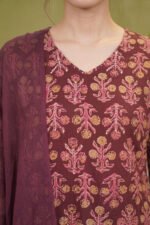 Detailed view of the three-quarter sleeves and side panel of a deep wine ethnic suit showcasing traditional Indian paisley and striped border prints.
