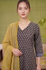 Close-up of the Midnight Buta Suit’s V-neckline highlighting the symmetrical beige floral buta prints on a deep black cotton base.