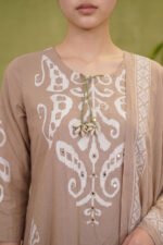 Close-up of the Mocha Print Kurti's neckline, highlighting the bold white ikat-style patterns, delicate mirror work embroidery, and a distinctive tie-up detail featuring natural cowrie shells.