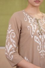 Detailed angled shot of the Mocha Print Kurti showcasing the three-quarter sleeves adorned with large white traditional motifs and subtle mirror work embellishments against a mocha brown base.