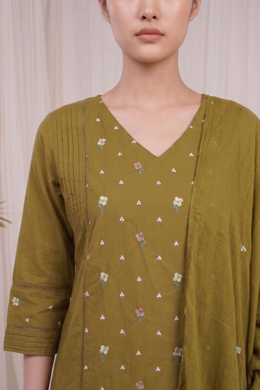 Close-up of the Olive Pintuck Kurti highlighting the classic V-neckline, delicate pastel floral motifs, and the beautifully structured side panel featuring fine pintucks and delicate insert lace detailing.