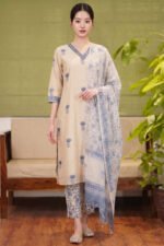 Full-length view of the Slate Print Kurti set in a natural kora beige, featuring muted blue floral motifs, matching printed straight trousers, and a lightweight, elegantly draped dupatta.