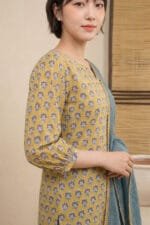 Detailed close-up of the Ziya Notch Kurti highlighting the 3/4 sleeve with its precisely gathered, fitted cuff. The image perfectly showcases the structured V-notch neckline and the intricate Dusty Blue floral motifs resting on a warm mustard base.