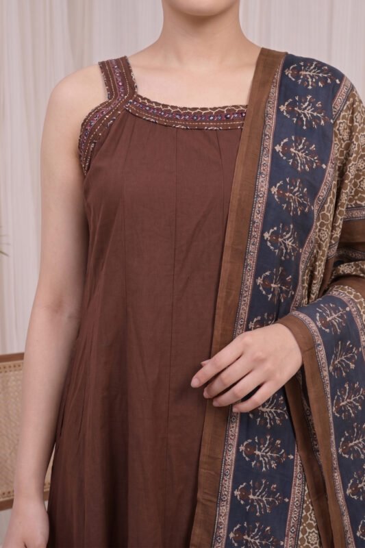 Close-up of the brown Ajrakh Kurti yoke showcasing the square neckline with printed border detailing and the technical precision of the vertical pleats.