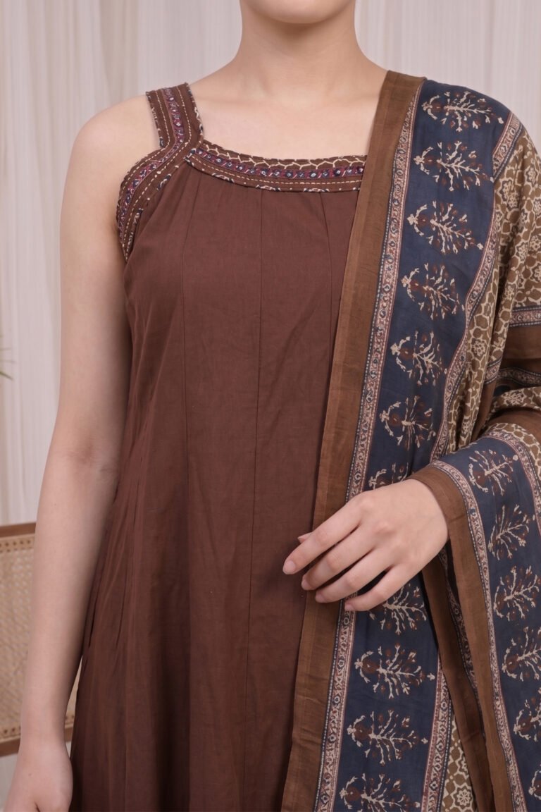 Close-up of the brown Ajrakh Kurti yoke showcasing the square neckline with printed border detailing and the technical precision of the vertical pleats.