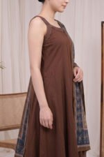 Side profile of the sleeveless brown Ajrakh Kurti highlighting the flared silhouette, side pleat construction, and high-quality fabric drape in a premium studio environment.
