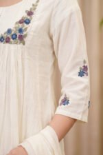 Detail shot of the Bloom Kurti sleeve, highlighting the premium finish and the elegant dusty blue and lavender floral motifs embroidered near the hem.