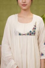 Close-up of the Bloom Kurti yoke highlighting technical precision in the garment construction, featuring a neat button placket, fine gathers, and intricate dusty blue and lavender floral embroidery.
