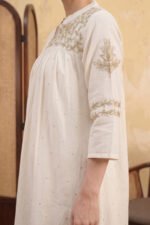 Side view of the Zari Kurti highlighting the gold floral embroidery on the sleeve and the high-quality texture of the ivory fabric.