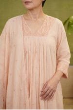Close-up front view of the Chanderi Blossom Cream Elegance Kurti, focusing on the precise technical construction of the V-neckline and the intricately embroidered yoke. The image showcases the accurate pleat alignment cascading down the front and the delicate scalloped border of the draped dupatta.